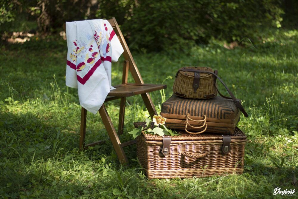 Picnic baskets in a field with a table cloth