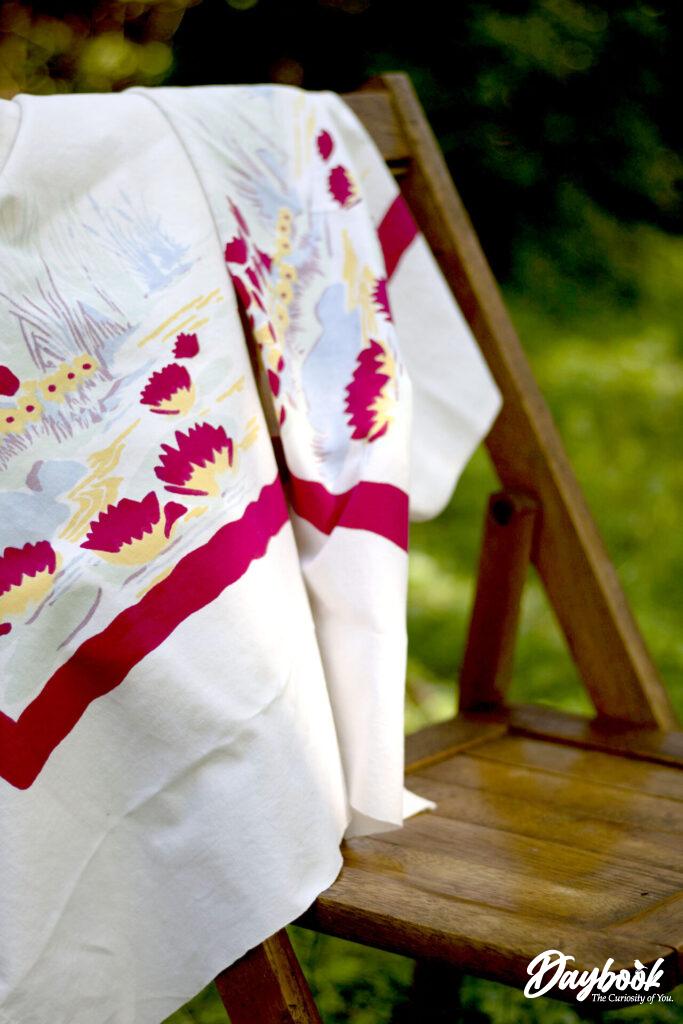 Picnic tablecloth on wooden folding chair.