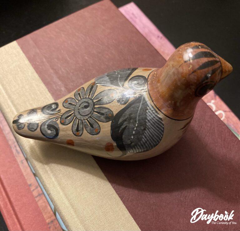 Mexican bird pottery on top of books