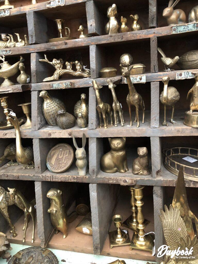A brass animal figure collection in a wooden display case
