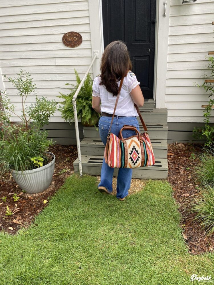 lady walking with bag into a cottage