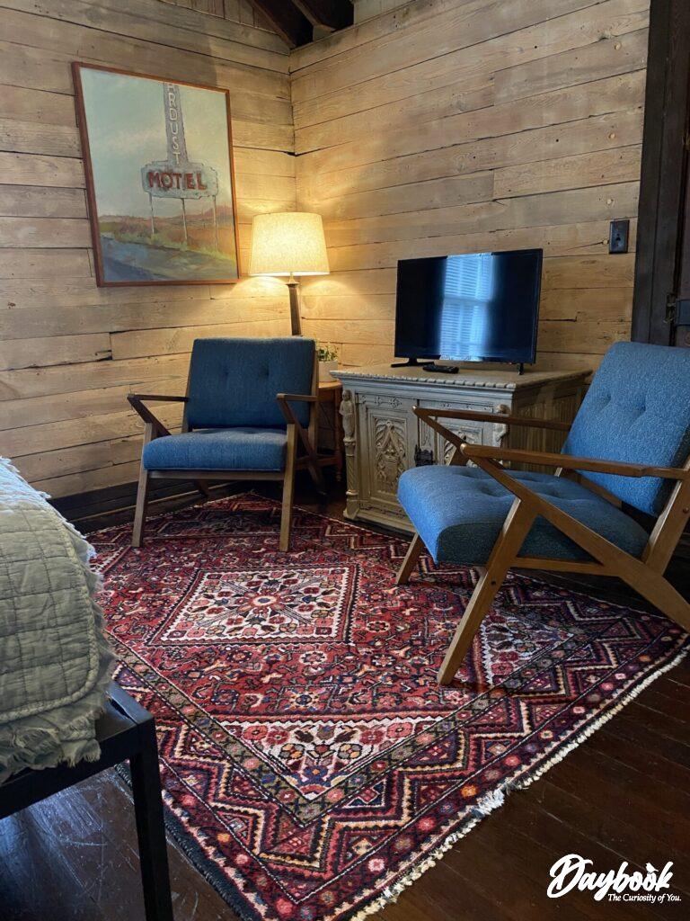 sitting area with two chairs, tv and rug