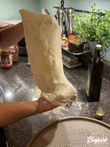 pizza dough being stretched