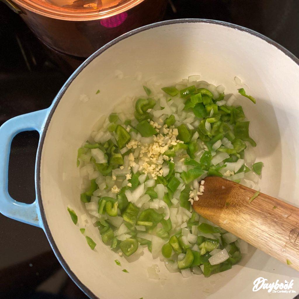 chopped green peppers and onions in a pan