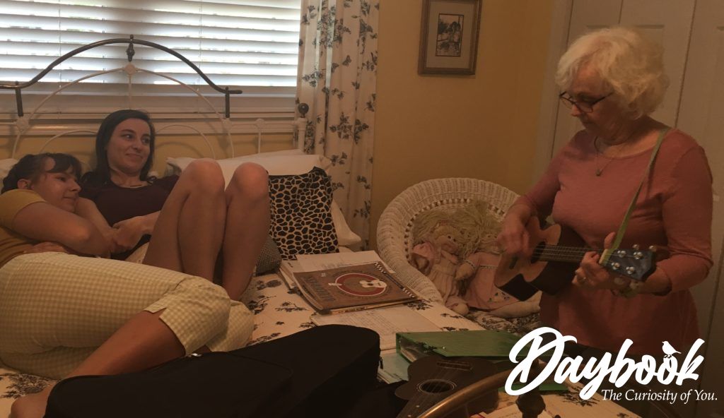 lady playing ukulele for two granddaughters