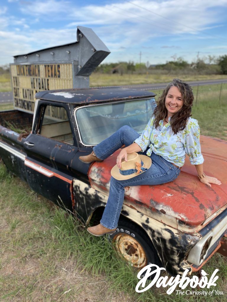 girl sitting on rusty old truck hood