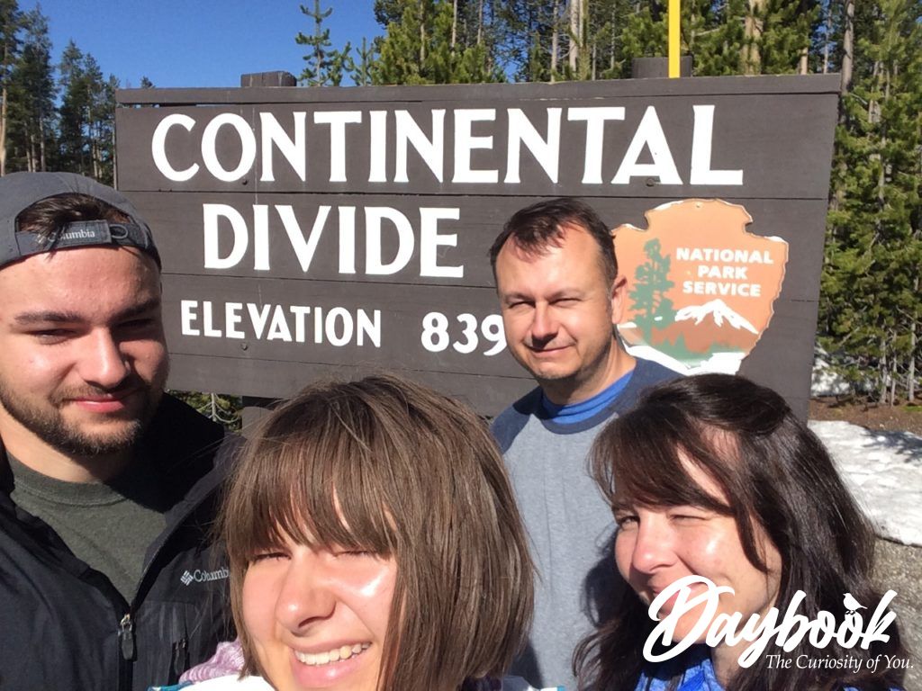 Family of four in front of Continental Divide Sign