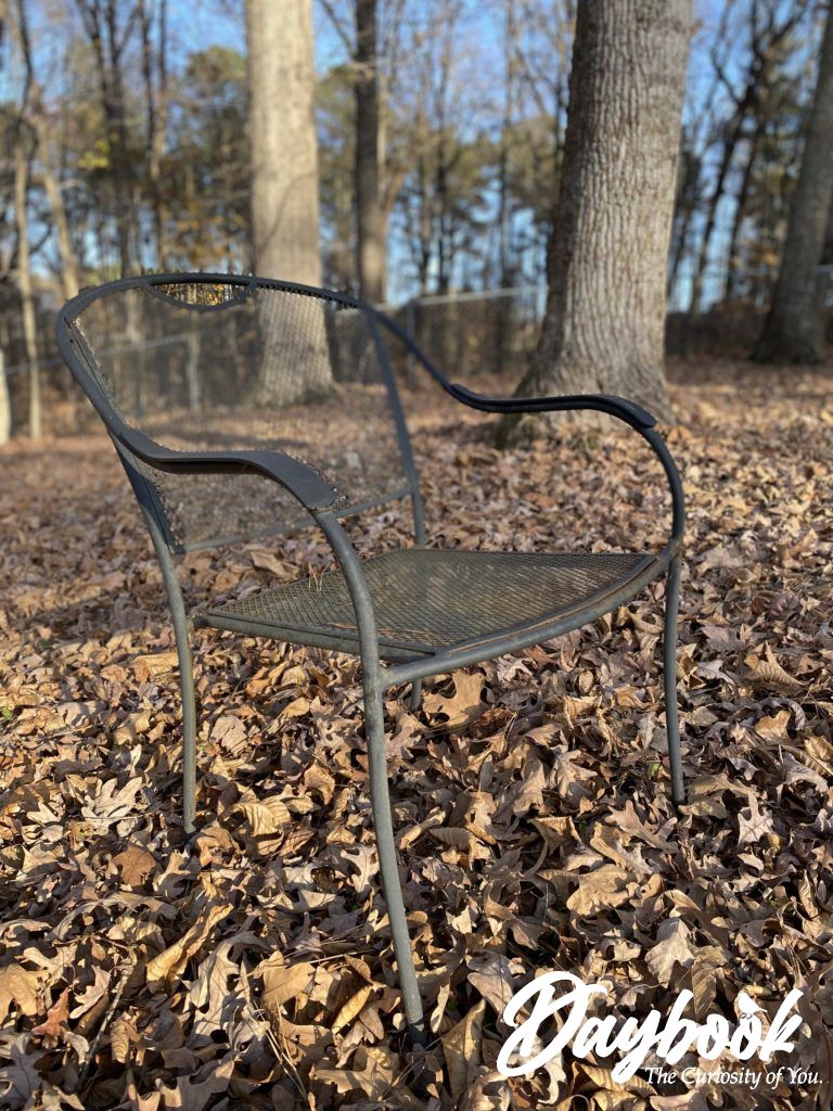 wrought iron chair in an empty winter field of leaves
