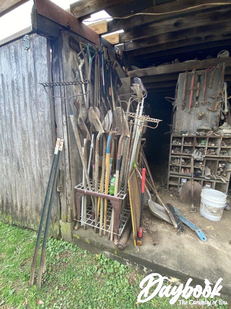 Local farm barn with garden tools propped up in the doorway