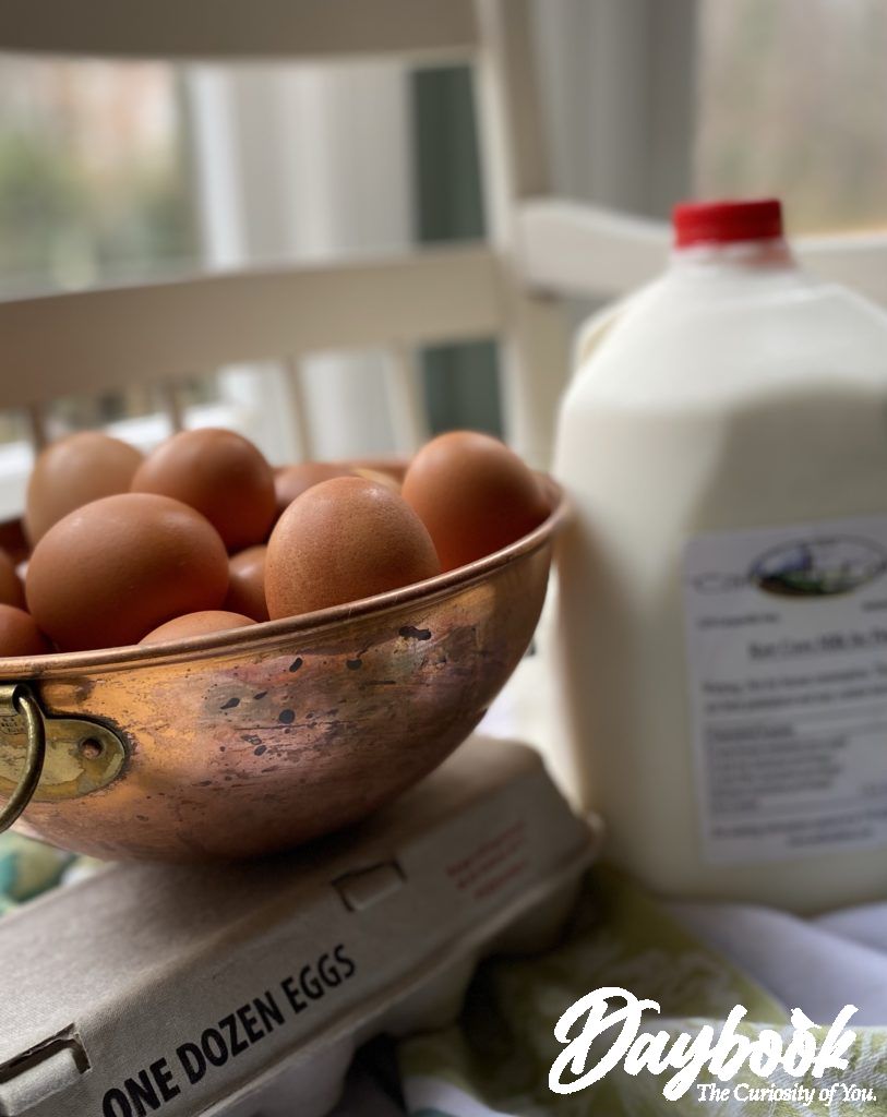 Fresh eggs and raw milk from a local farm on a white bench in a kitchen