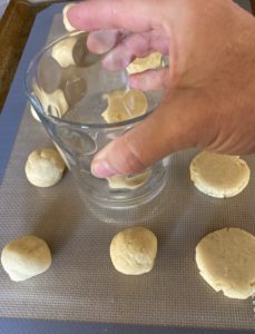 Using a clear glass to press cookie dough into rounds