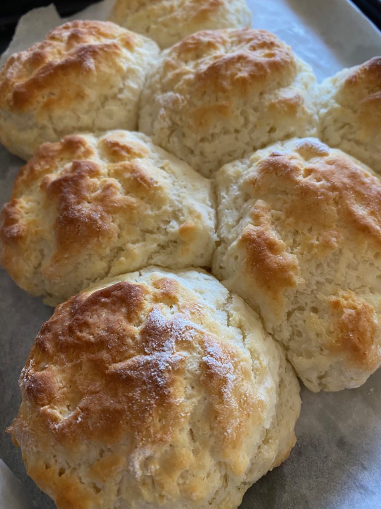 A pan of 3 ingredient craveable biscuits on a metal pan with parchment paper.