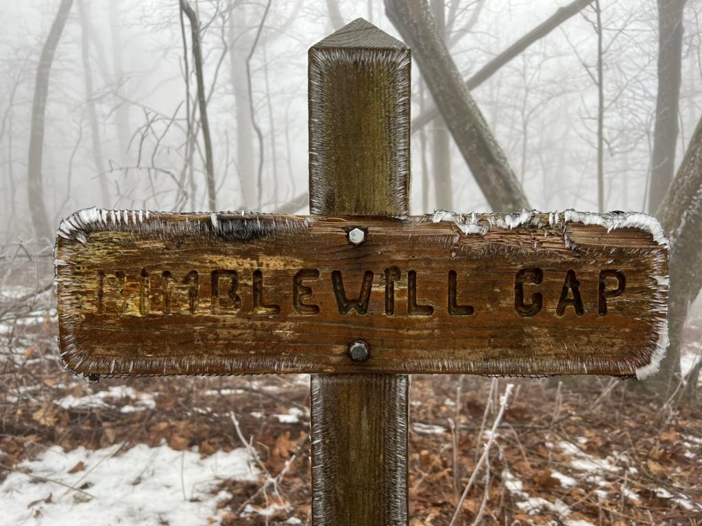 A wooden sign on a trail that reads Nimblewill Gap.