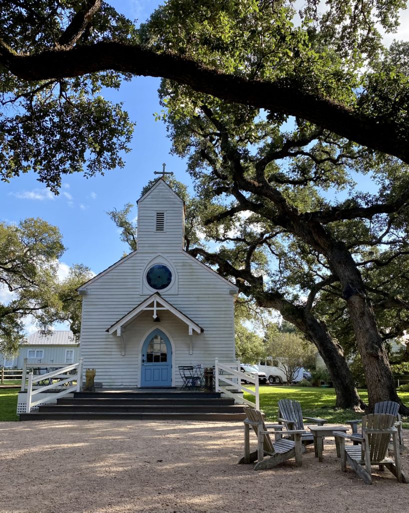 A small local church in Roundtop Texas that sits under an oak tree.