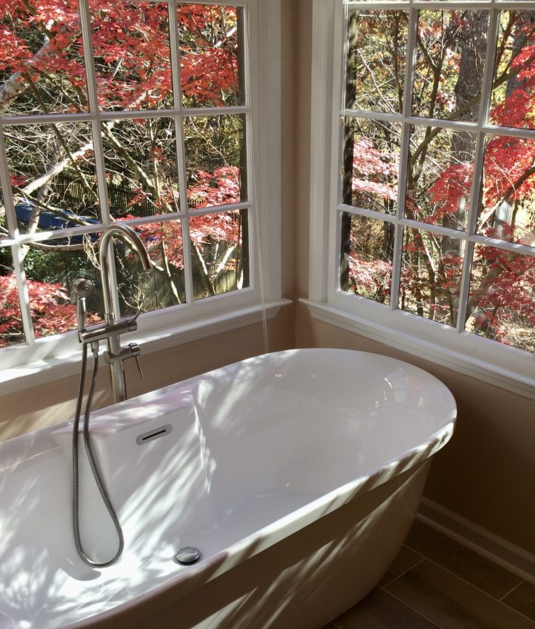 The view of a maple tree from the bathroom window of a home.