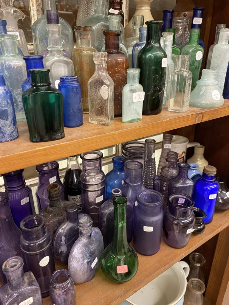 A collection of vintage colored medicine bottles.