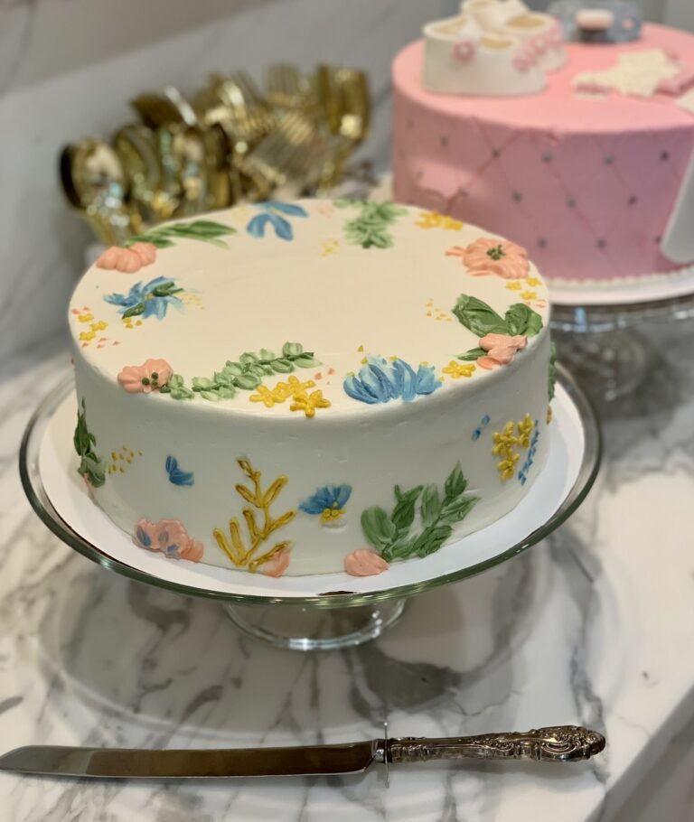 Two beautifully decorated cakes at a baby shower