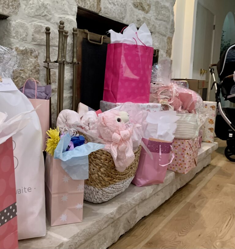 a row of gifts on a fireplace hearth during a baby shower