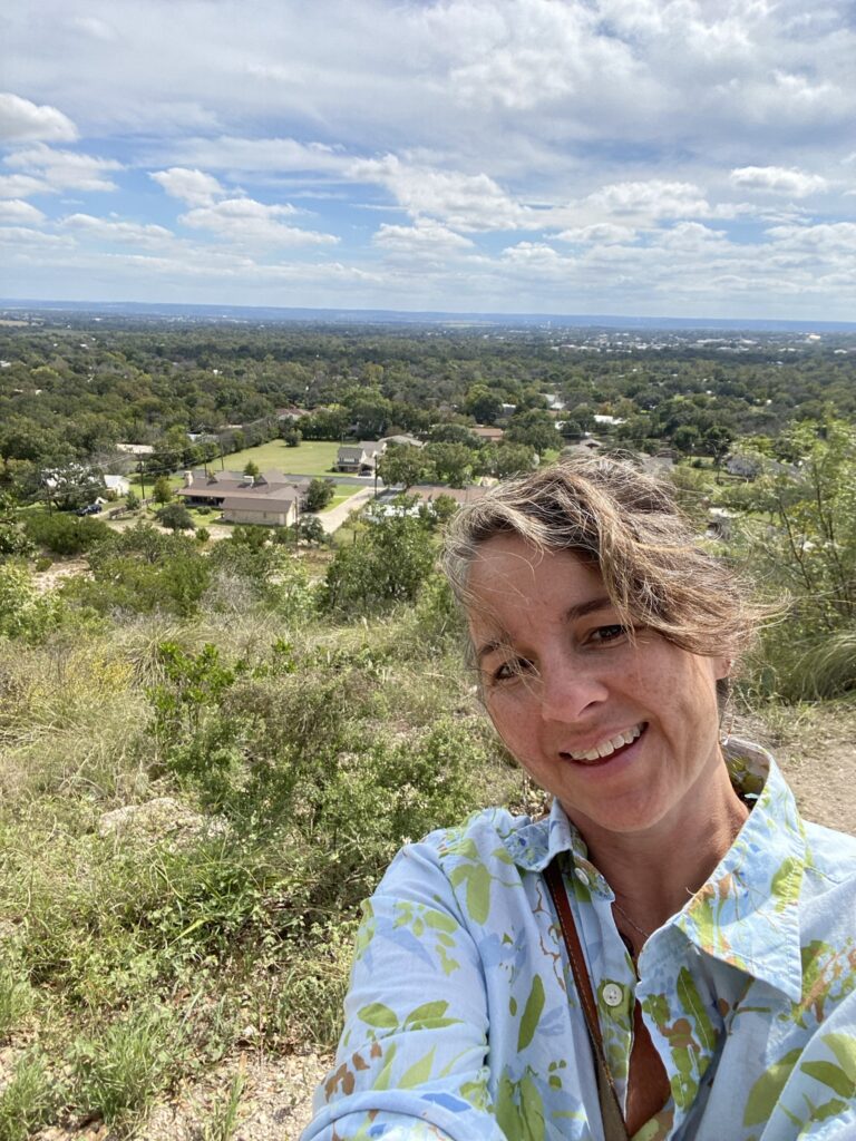 A lady on top of a mountain overlooking Fredericksburg Texas