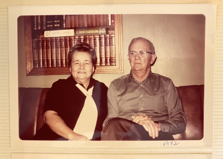 Mammaw and Pappaw sitting together on their sofa posing for a picture.