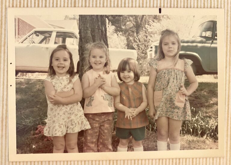 Four children standing together outside in 1974.