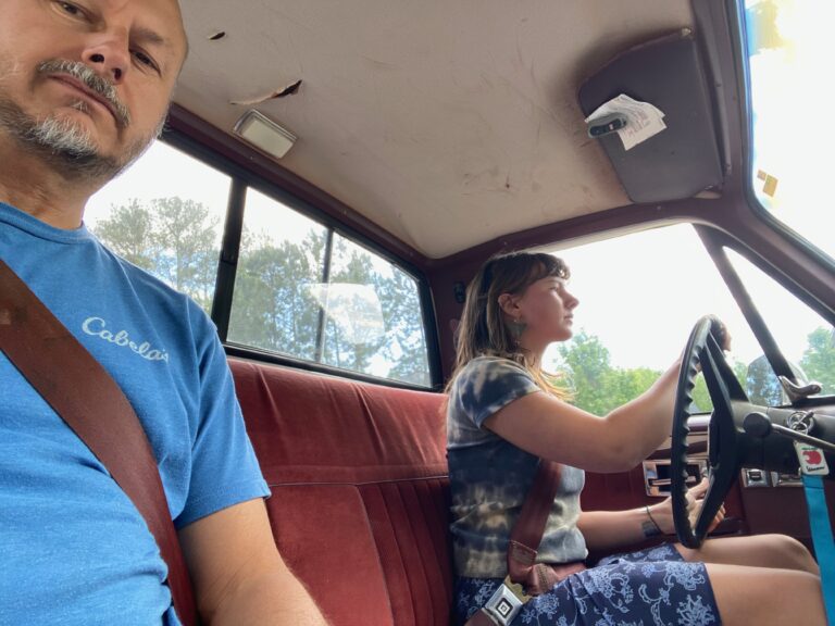 Father and daughter in a white 70s Chevy Silverado truck ready to ride