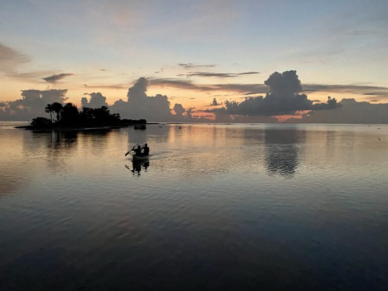 Sunset view of the Gulf of Mexico with a kayak floating to shore